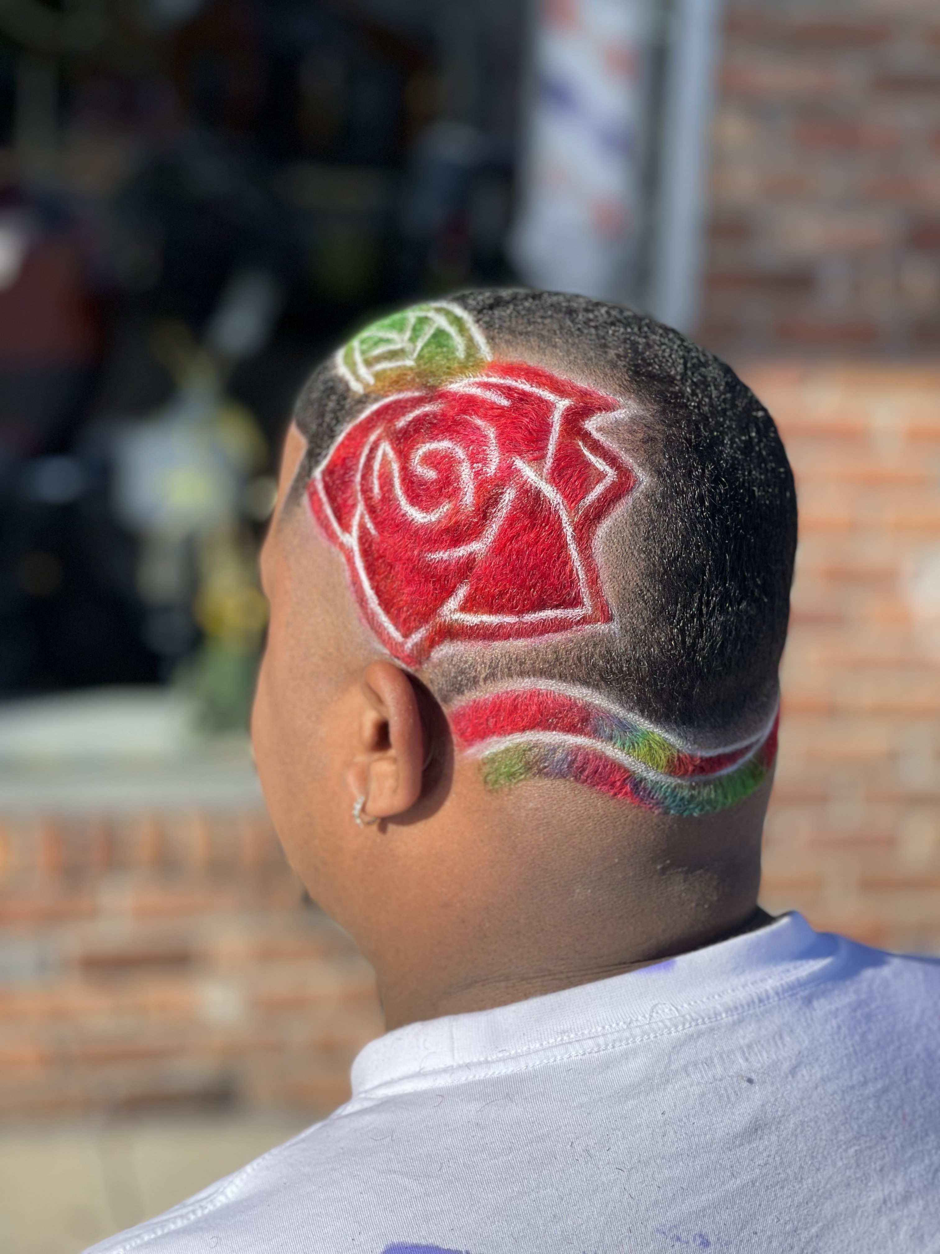 Artistic rose design haircut with red coloring